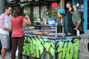 Man and woman try food from a food stand during College Park JazzFest 2016.